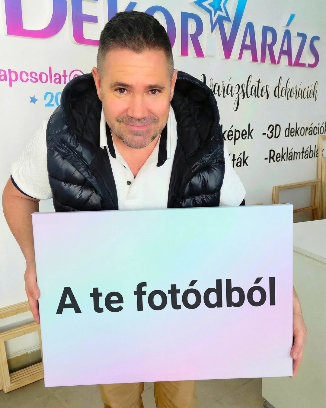 Jelencsity Miklós téglalap alakú vászonképet tart – DekorVarázs, egyedi vászonkép saját fotóból Baján